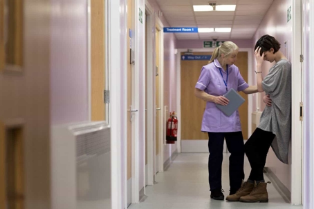 Nurse consoles a patient in a hospital hallway